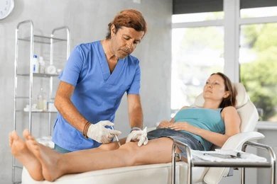 Medical professional supporting an osteoarthritis patient during a stem cell therapy session at Nexus Clinic