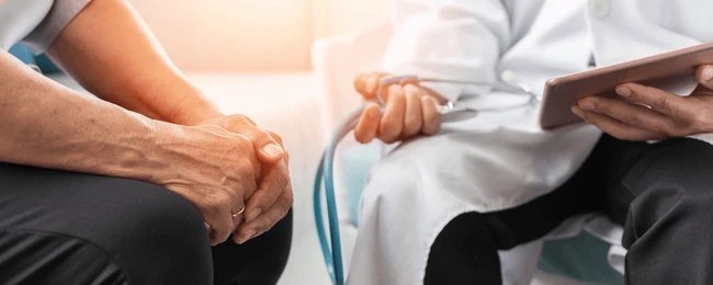 Medical professional offering support and care to a Parkinson’s patient during a stem cell therapy consultation at Nexus Clinic.